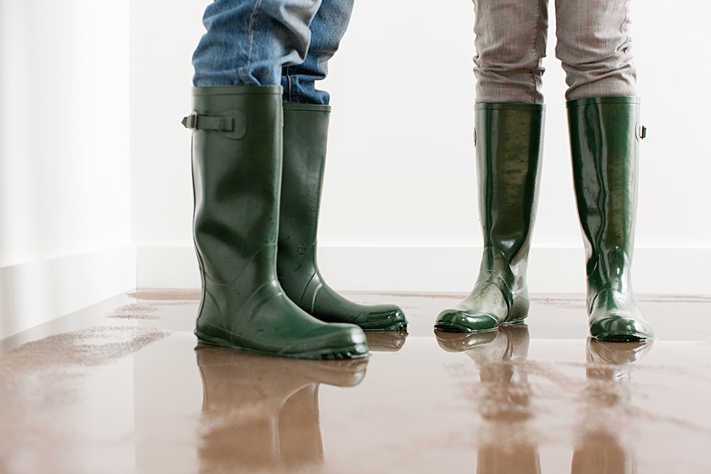 Young couple in wellington boots on flooded floor in Santa Clara, CA