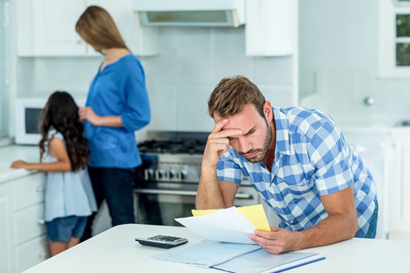 husband stressed while looking over a bill