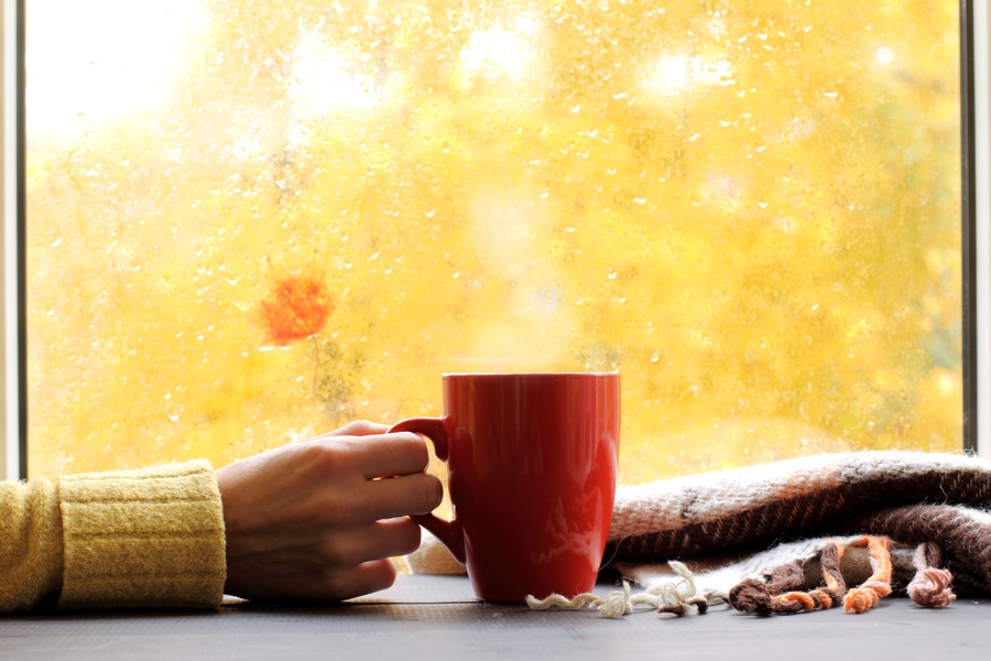 red mug of hot drink, when behind a window is rain in autumn in San Jose, CA