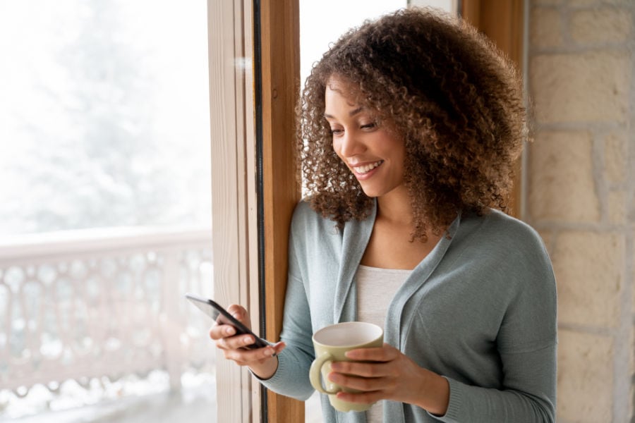 Woman texting by a window.